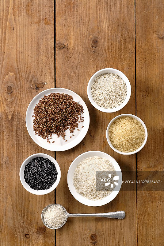 木质表面上碗里的各种米饭图片素材