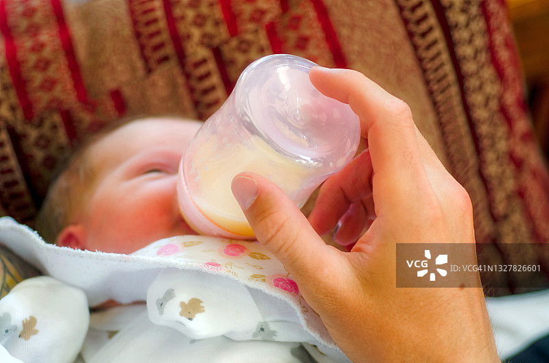 抱着奶瓶的新生儿图片素材