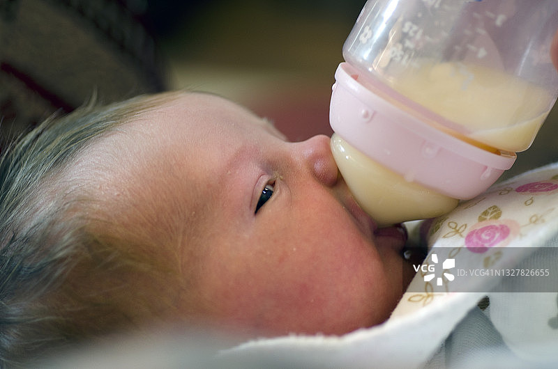 抱着奶瓶的新生儿图片素材