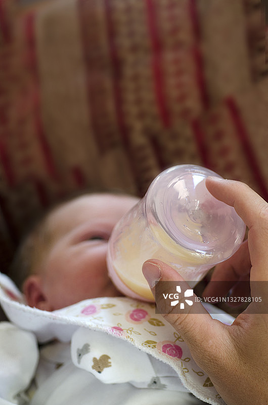 抱着奶瓶的新生儿图片素材