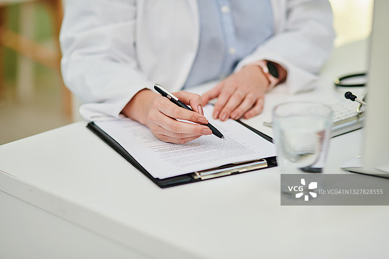 医生在办公桌前记录图片素材