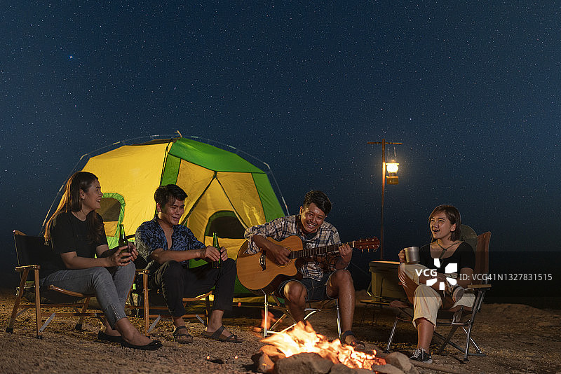 一群亚洲游客朋友饮酒弹吉他图片素材