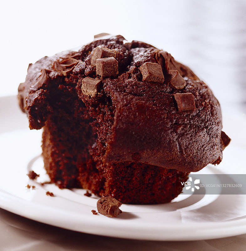 复活节庆祝活动：白色盘子上带巧克力块的巧克力松饼图片素材