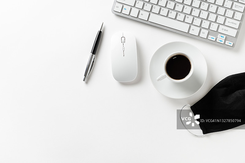 办公室安全卫生措施合规：预防新冠疫情，桌面防护面罩、键盘、鼠标、笔和咖啡杯图片素材