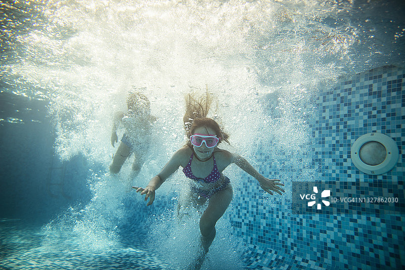 两个快乐的孩子跳进泳池图片素材