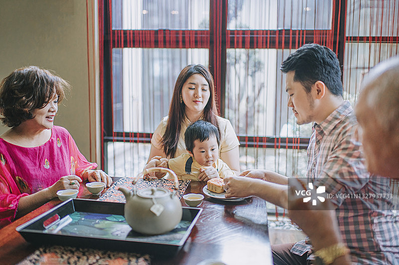中国家庭在下午茶聚会上享用传统中秋月饼和中国茶图片素材