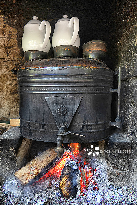 花园里带木柴的茶炊上的瓷茶壶。图片素材
