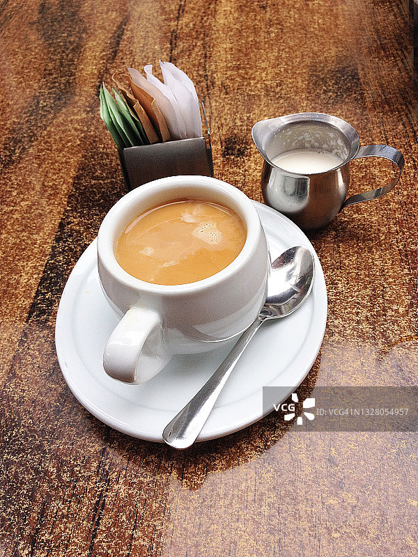 搭配多种甜味剂和一小罐奶油的咖啡图片素材