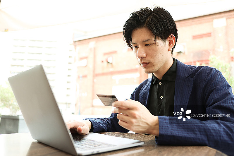 年轻的亚洲男人在线购物图片素材