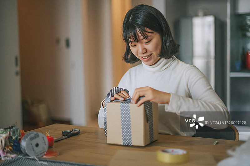 亚洲华人女人准备网店包裹发货。图片素材
