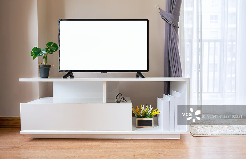 现代客厅白色墙壁背景柜子上的智能电视。带有平板电视的现代白色架子图片素材