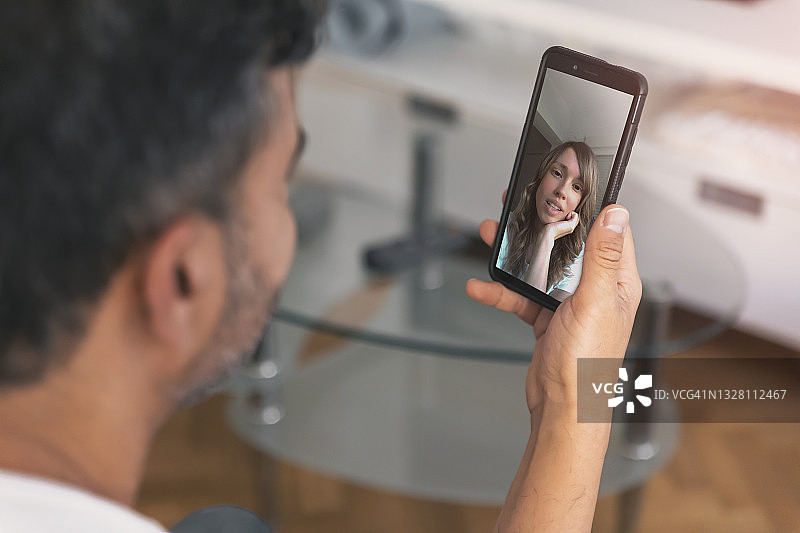 男人用智能手机与女人进行视频通话图片素材