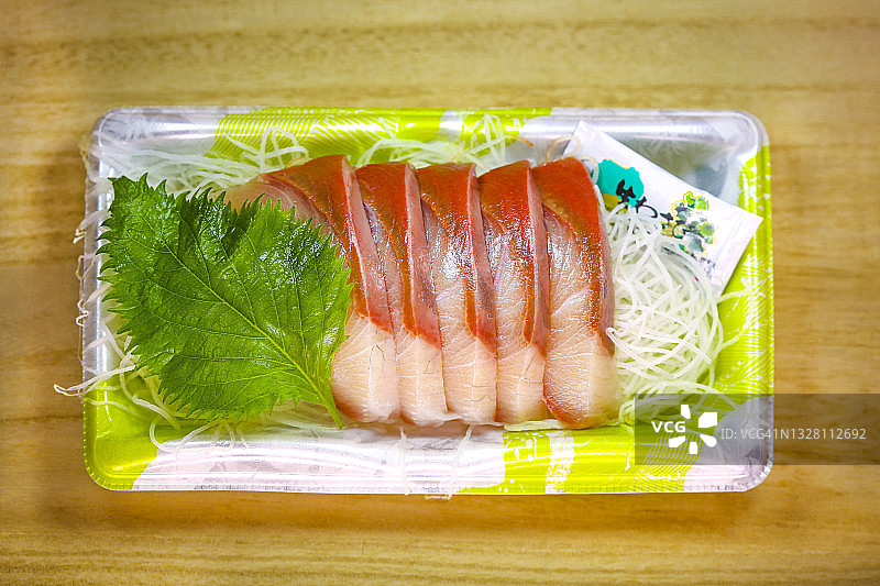 一次性塑料托盘中的黄尾鱼生鱼片图片素材