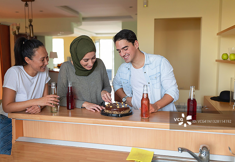 一位中国少数民族年轻女子与不同民族的密友一起庆祝生日图片素材