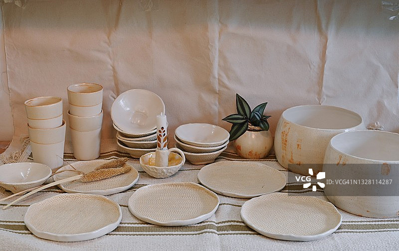 桌上的陶瓷碗、玻璃杯、盘子、花瓶和烛台图片素材