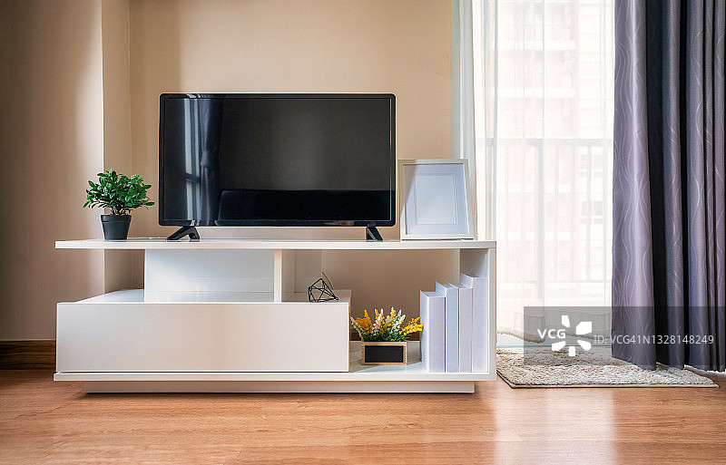 现代客厅白色墙壁背景柜子上的智能电视。带有平板电视的现代白色架子图片素材