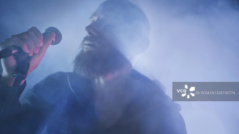 摇滚歌手在舞台灯光下现场演唱图片素材