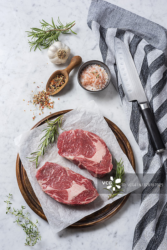 两片带香草和调味料的生牛排图片素材