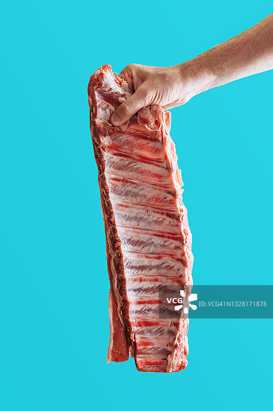 白人男子手持生猪肋排，反对食用红肉图片素材