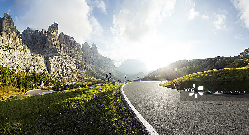 阳光明媚的日子里，空旷的沥青路和远处的山脉图片素材