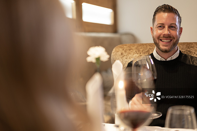 在餐厅里拿着酒杯的快乐男人图片素材