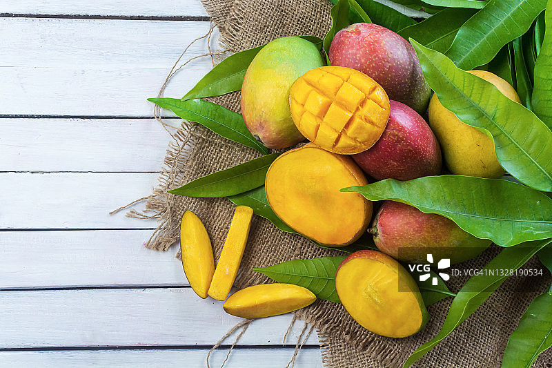 新鲜成熟的芒果热带水果与绿叶图片素材