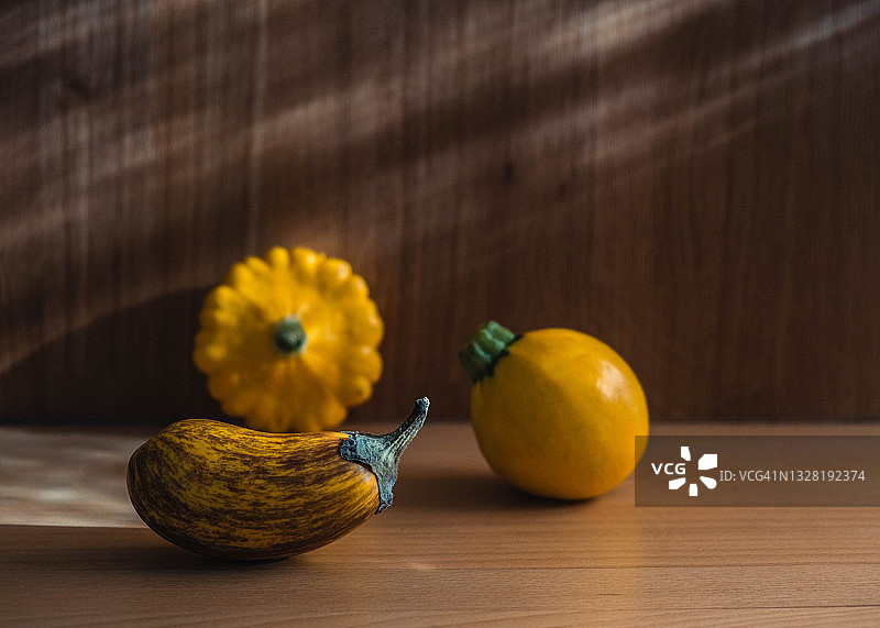 木桌上的成熟黄色茄子和碟瓜（葫芦科）图片素材