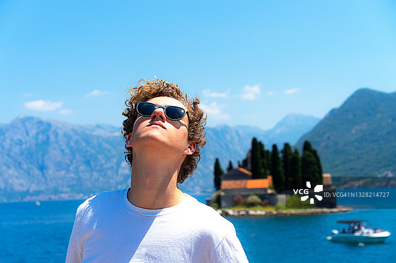 年轻男人或青少年穿着白色T恤旅行，探索美丽的地中海风光图片素材