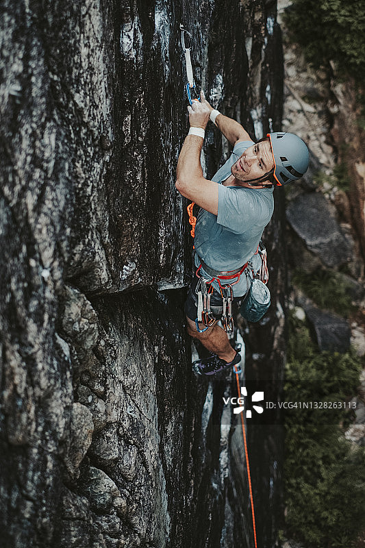 在加拿大斯阔米什攀岩：攀岩者在垂直岩壁上悬挂时扣紧绳索图片素材