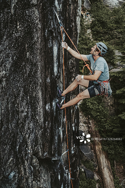 攀岩者在陡峭的岩壁上坠落后，悬挂在攀岩绳的末端图片素材