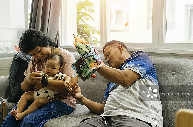 亚洲家庭的温馨时刻：爷爷奶奶和孙女在家玩耍图片素材