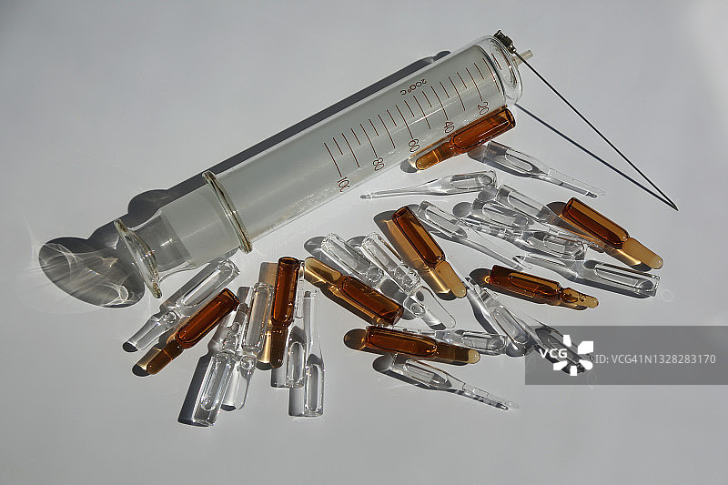装满玻璃安瓿的大型旧可重复使用注射器图片素材