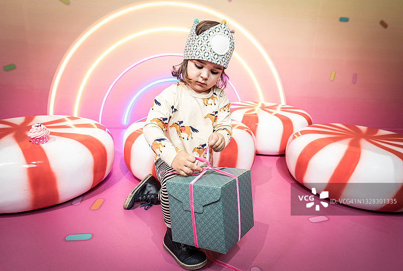 在糖果屋打开礼品盒的小女孩图片素材