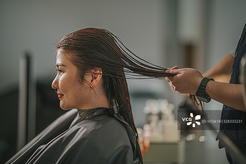 华裔发型师为顾客梳理长发图片素材