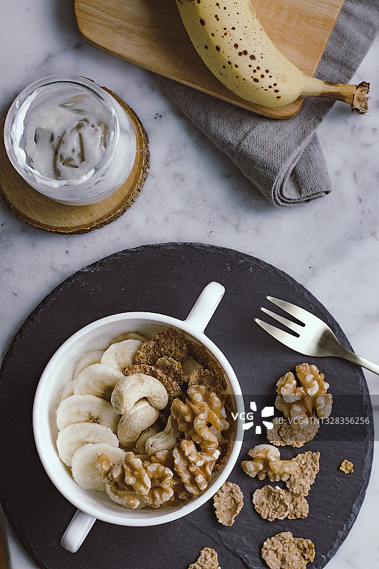 含坚果、谷物、香蕉和酸奶的健康早餐俯视图图片素材