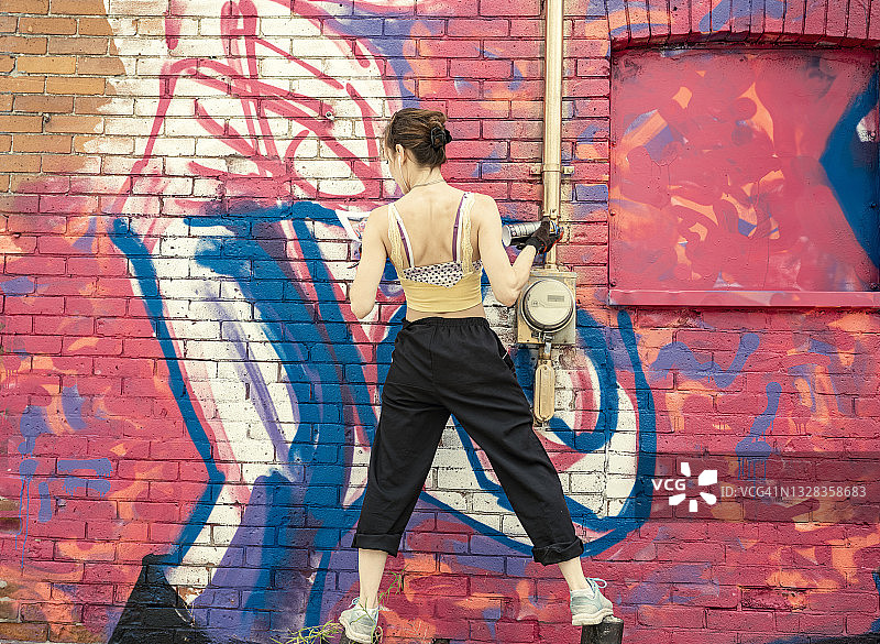 年轻女人在房子上画壁画图片素材