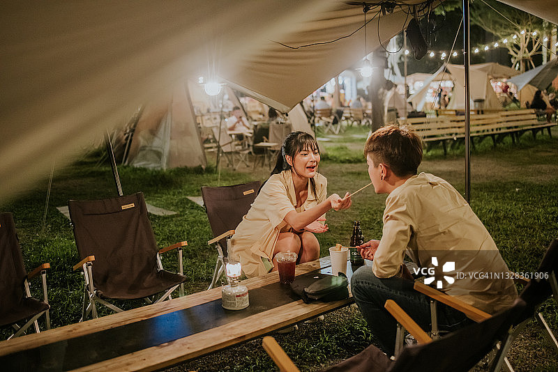 泰国年轻女孩喂男友炸鸡丸，自信快乐的瞬间图片素材