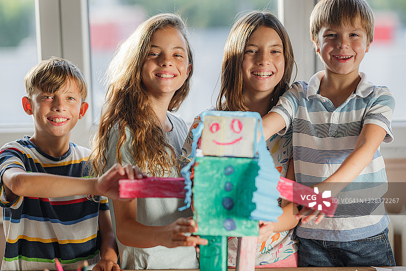 一个快乐的孩子和纸板机器人的肖像图片素材