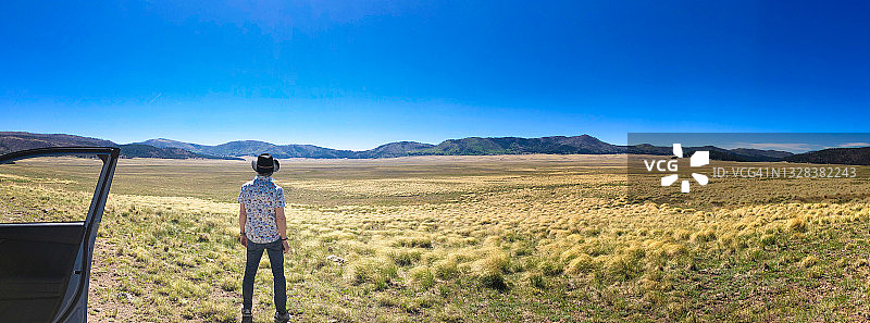 男人在车外欣赏新墨西哥州瓦列斯卡尔德拉荒野全景图片素材