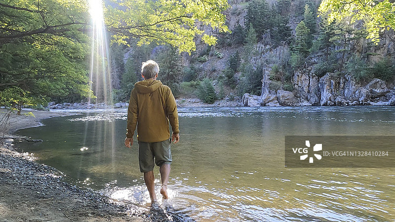 清晨男人走进溪流池塘图片素材