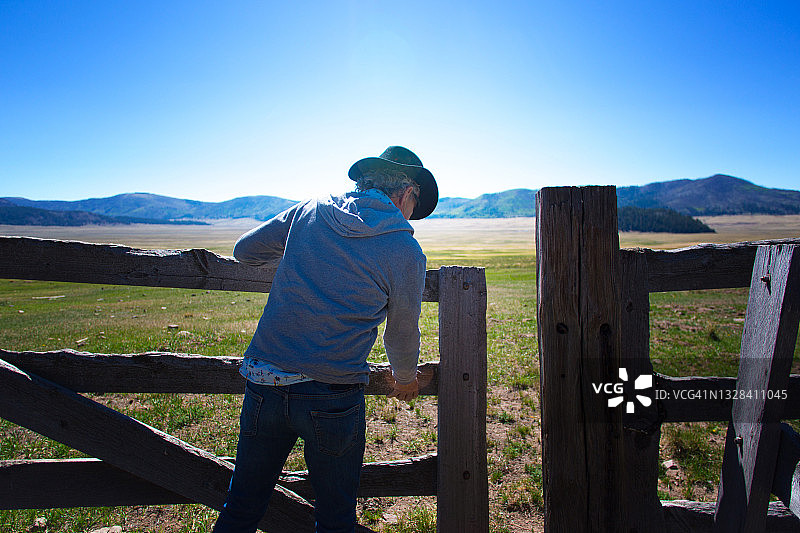 牛仔抬起旧式木制牧场围栏门图片素材