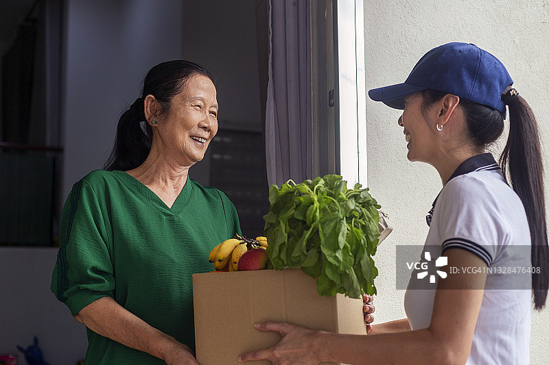年轻女人为年长女人送去食品杂货图片素材