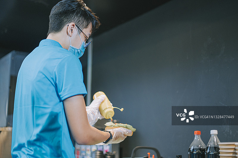 中国的快餐店员工在娱乐场所电影院的售货亭准备热狗三明治图片素材