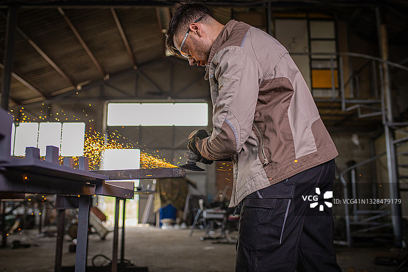在金属工厂，工程师使用砂轮切割钢材图片素材