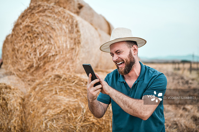 快乐的农民在干草地上参加视频会议图片素材