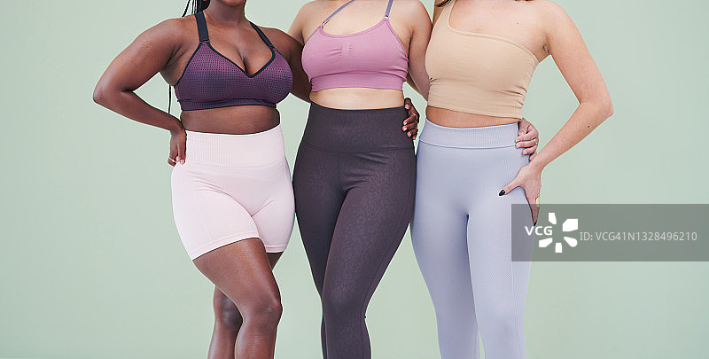 一群穿着健身服的女士的局部特写，背景为绿色图片素材