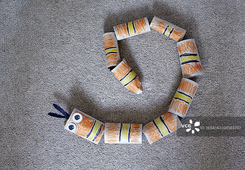 涂成蛇形的卷纸架在地毯上图片素材