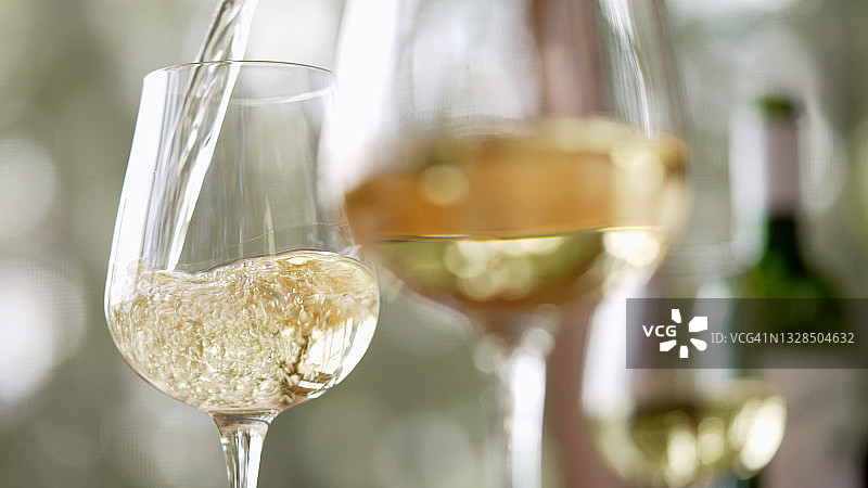 白葡萄酒倒入酒杯中图片素材