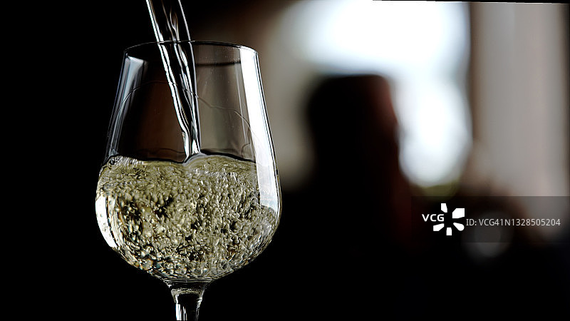 白葡萄酒倒入酒杯中图片素材