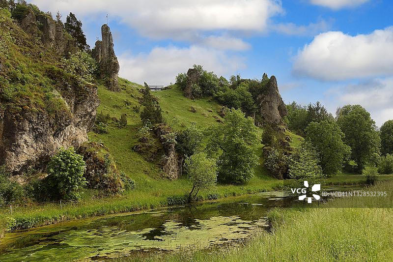 新豪斯（奥弗塞斯）教区村庄墓地附近的岩石塔，带藻类的池塘，上弗兰肯，巴伐利亚，德国图片素材